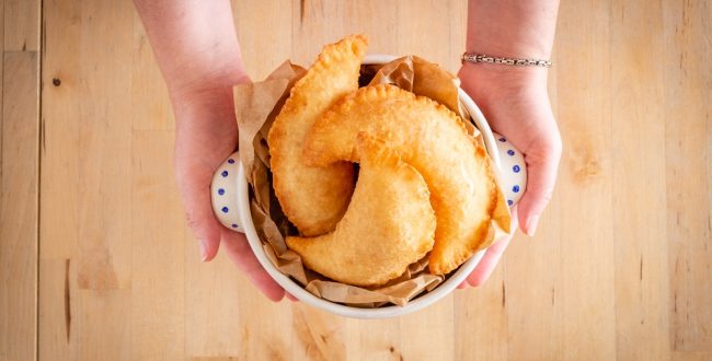 Female Hands Holding A Bowl Full Of Fried Panzerotto. Traditional Food Of Puglia, Italy