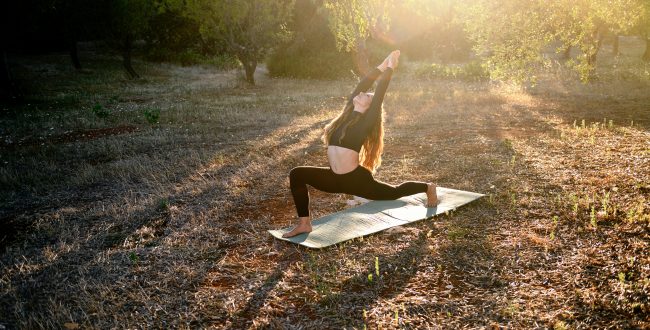 Young Girl Is Doing Yoga Strethching On The Mat On The Olive Grove At Sunset