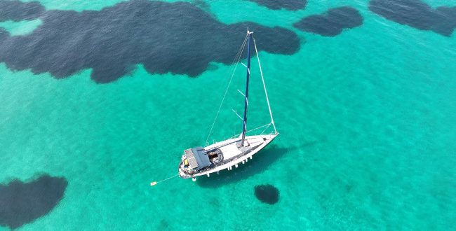 Aerial Drone Ultra Wide Panoramic Photo Of Beautiful Sail Boat With White Sails Anchored In Tropical Exotic Bay With Emerald Clear Sea